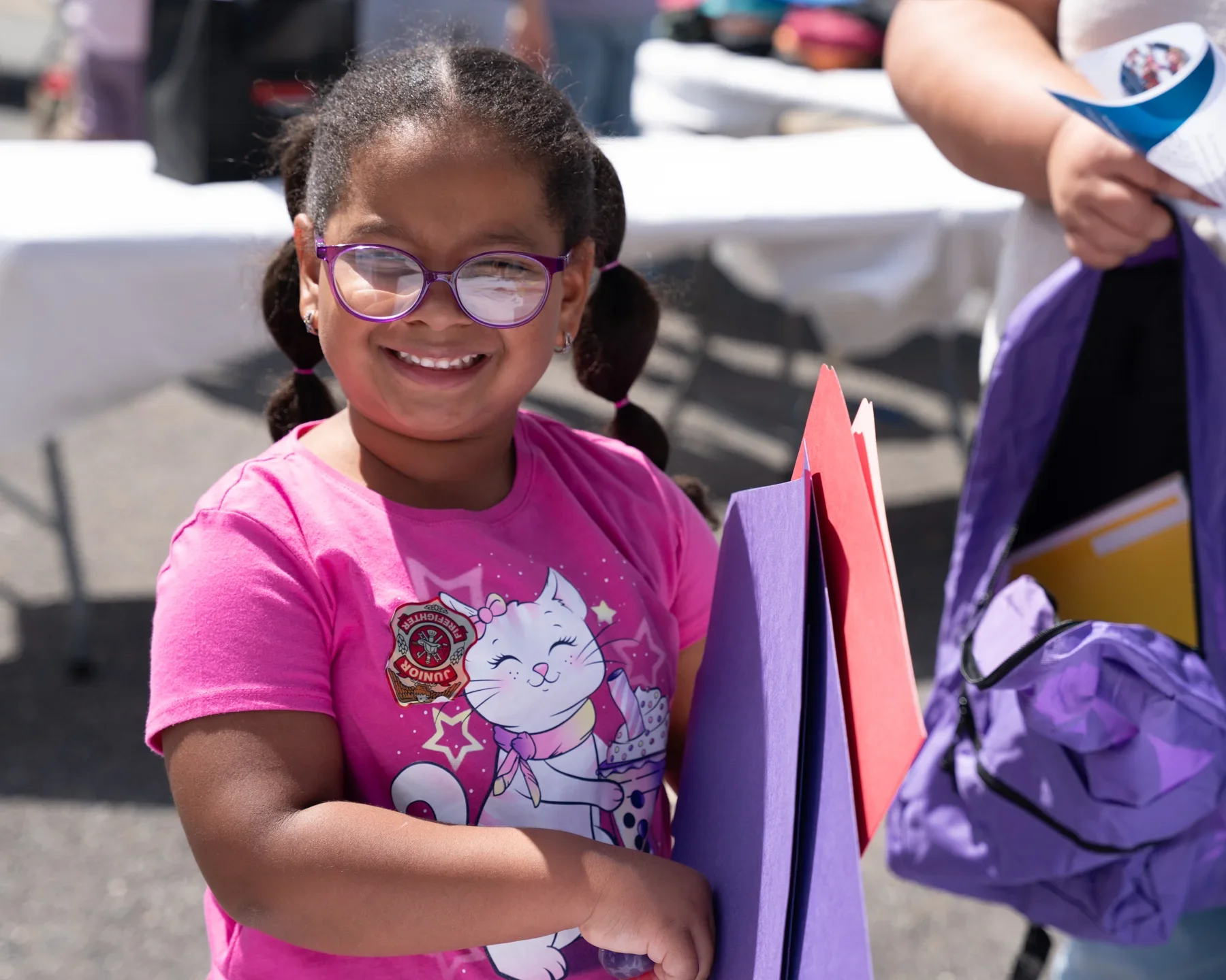 A student receiving a blue backpack during the Pedro Martinez Foundation Back-to-School Drive