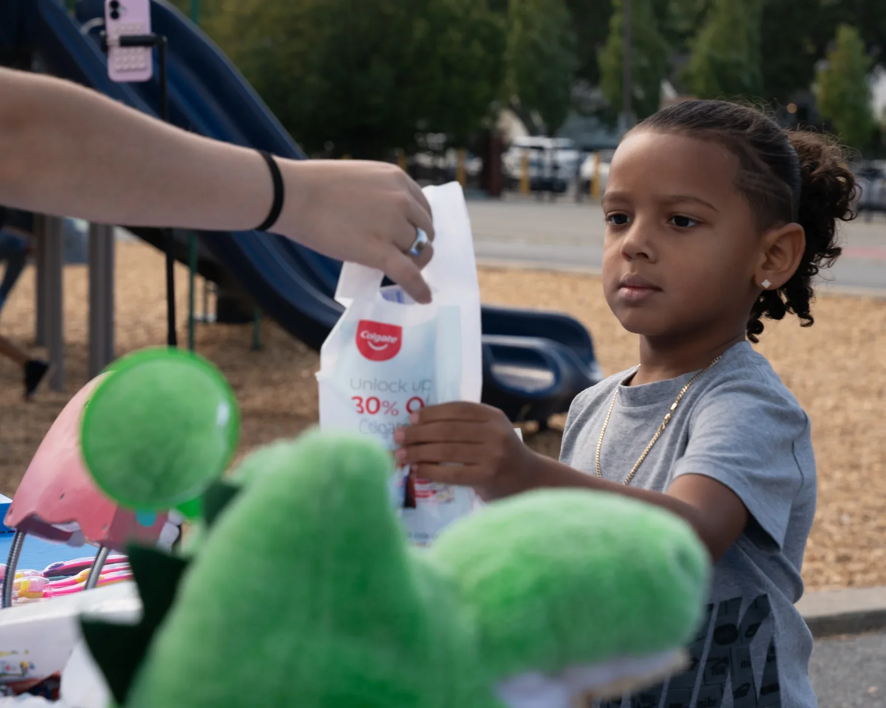 A volunteer handing a backpack to a student