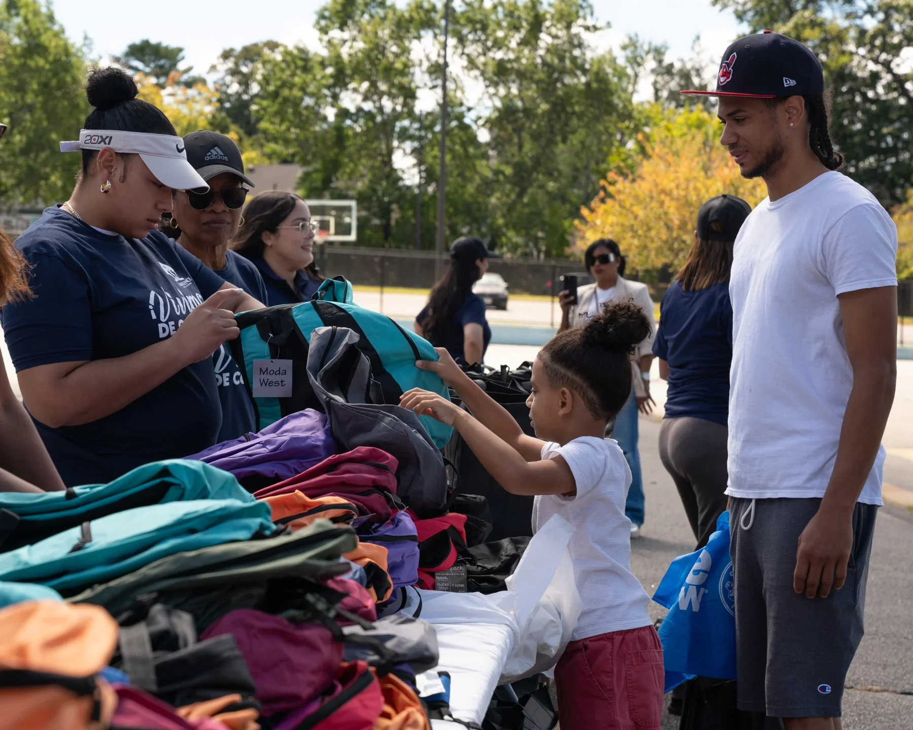 Volunteers distributing backpacks and school supplies